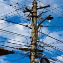 vertical-low-angle-shot-lot-electricity-wires-cloudy-sky